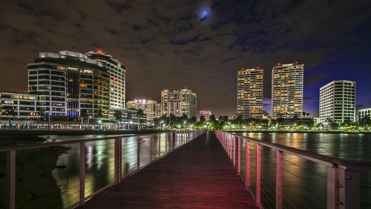 Downtown West Palm Beach waterfront at night, seen from a pier on the Lake Worth Lagoon